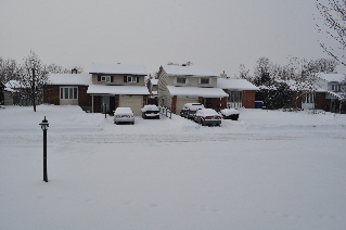 Fresh snowfall leaves the street out front looking serene